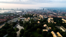 Luftfoto af Aarhus Universitet og byens skyline i morgendis – arkitektonisk overblik fanget af Kasper Hornbæk.