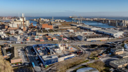 Stort dronebillede af boreaktivitet ved havneområde, med udsigt over containerterminal og boreplads fra Innargi.