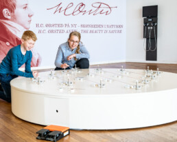 To børn eksperimenterer med en interaktiv installation om elektromagnetisme ved H.C. Ørsted-udstillingen på Science Museerne i Aarhus.