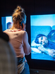 Gæst lytter til fortælling om kvinders oplevelser ved interaktiv installation på Science Museerne.