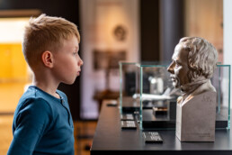 Dreng kigger fascineret på en buste af H.C. Ørsted under en udstilling på Science Museerne i Aarhus.