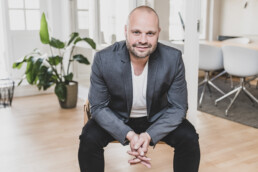Professionelt portræt af mand i jakkesæt i moderne kontormiljø – erhvervsfotograf til hjemmeside og LinkedIn